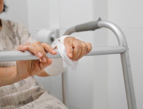 Personne âgée utilisant un déambulateur dans une salle de bain aménagée avec des équipements pratiques.
