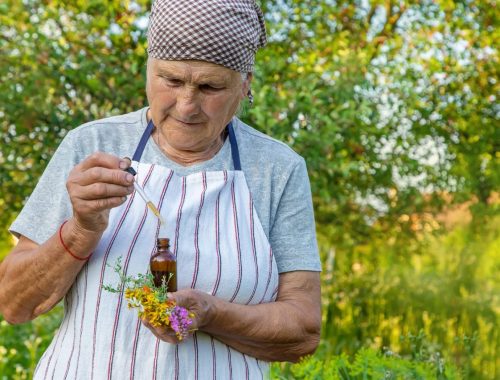 Une personne âgée vérifie ses médicaments et des compléments à base de plantes sur une table.