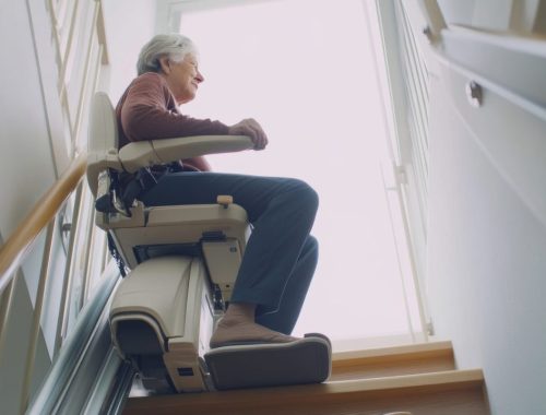 Personne âgée se levant d’un fauteuil releveur après une opération de la hanche.